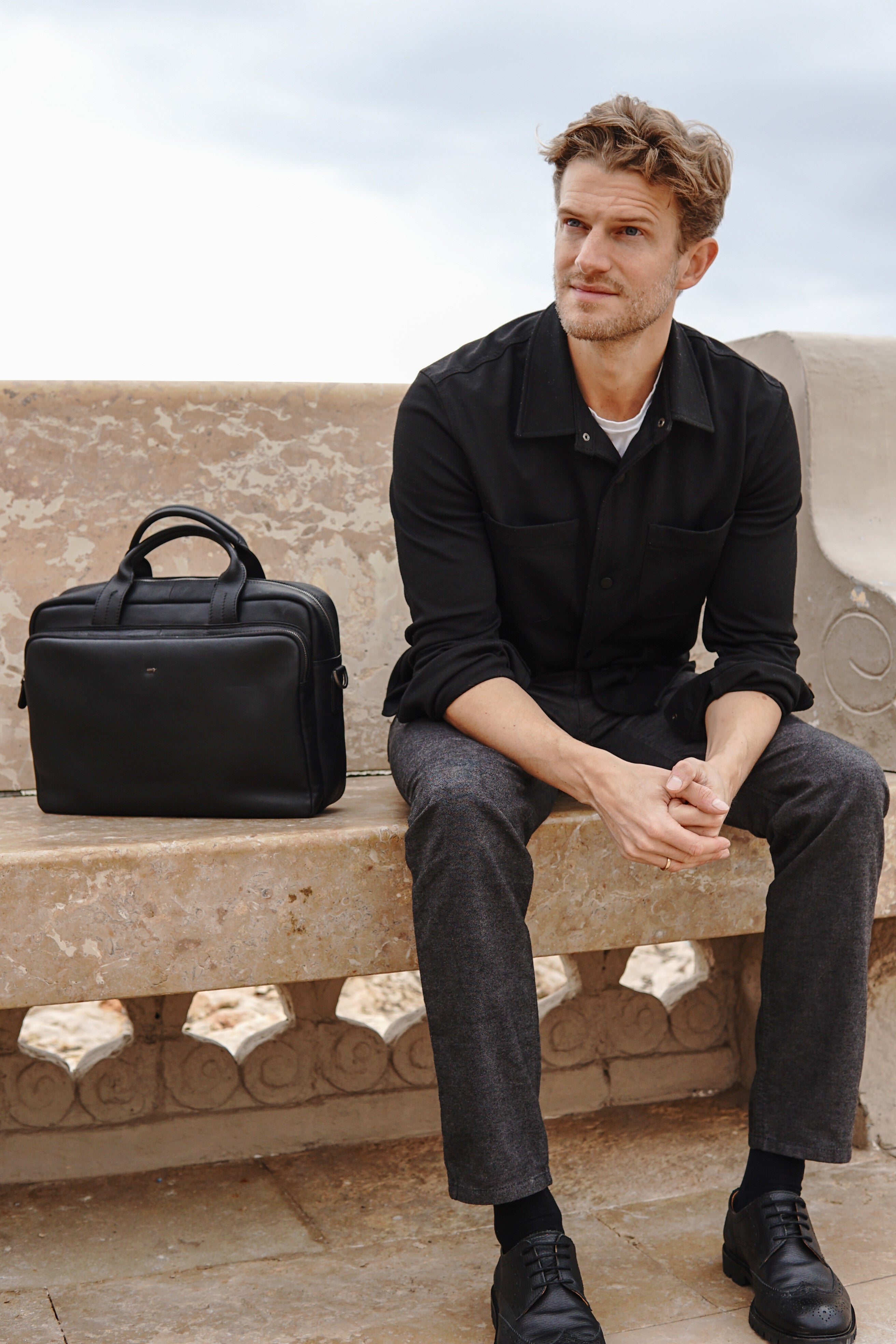 Mann auf einer Bank sitzend im Smart Casual Herrenlook